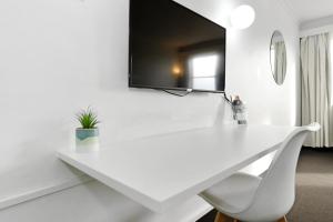 escritorio blanco con silla y espejo en Coach House Launceston, en Launceston