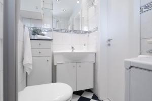 a white bathroom with a sink and a toilet at Haus Dieksee Holm Seeromantik in Malente