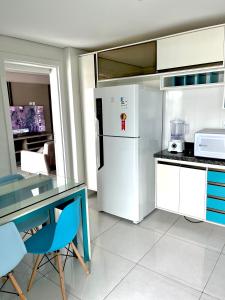 uma cozinha com um frigorífico, uma mesa e cadeiras em Residencial renaissance em Boa Vista