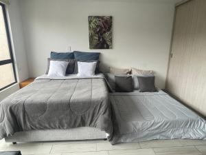 a bedroom with a large bed with two pillows at Hermoso apartamento con terraza, excelente ubicación cerca al centro de la ciudad in Bogotá