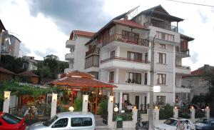 a white building with cars parked in front of it at Guest House Lazur in Obzor +27 photos