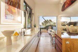 Una cocina con fregadero y una sala de estar. en Hastings Park: Lavish Ocean Vista Luxury, en Noosa Heads