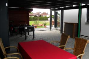 a patio with a red table and chairs and a table at Apartment Suda in Rheinhausen