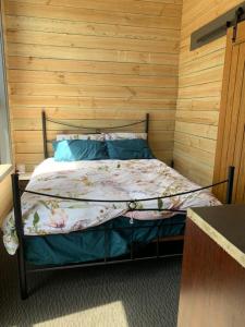 a bed in a room with a wooden wall at Taylor Bay Country Club in Eildon