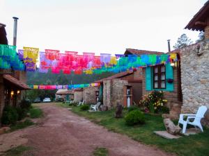 a string of colorful flags hanging over a street at Luchita Mia Eco Cabañas Boutique in Zacatlán