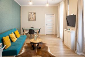 a living room with a blue couch and a table at Piata's Hidden Apartment in Braşov