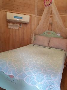 Cama en habitación con mosquitera en Finland Village Pension en Geoje 
