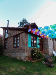une maison avec un tas de drapeaux accrochés à elle dans l'établissement Luchita Mia Eco Cabañas Boutique, à Zacatlán