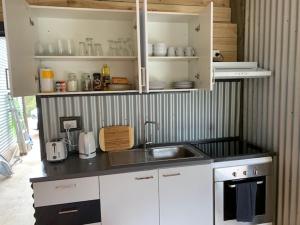 a kitchen with white cabinets and a sink and a stove at Taylor Bay Country Club in Eildon