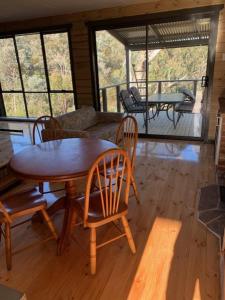 a living room with a wooden table and chairs at Taylor Bay Country Club in Eildon