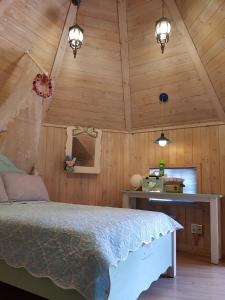 1 dormitorio con 1 cama en una habitación con paredes de madera en Finland Village Pension en Geoje 