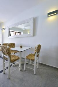 a white table with chairs and a mirror on a wall at Kalidon beach Hotel in Kokkari