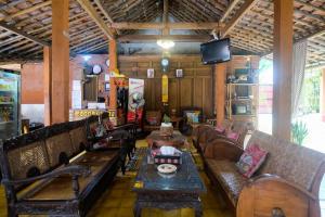 un restaurant avec des canapés, une table et une télévision dans l'établissement RedDoorz Syariah near Akmil Magelang, à Magelang