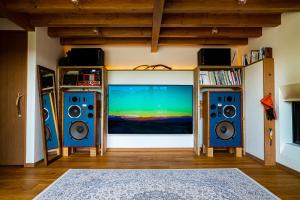 sala de estar con 2 altavoces y TV de pantalla plana en 野尻湖の絶景を楽しむ、貸切サウナ付き一軒家 Anoie（あの家）, en Shinano