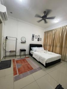 een slaapkamer met een bed en een plafondventilator bij Homestay Shah Rizki@Bali Resident Melaka-muslim friedly in Melaka