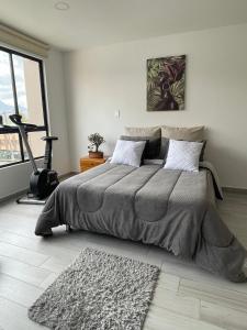 a bedroom with a large bed and a large window at Hermoso apartamento con terraza, excelente ubicación cerca al centro de la ciudad in Bogotá