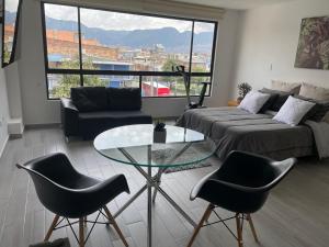 uma sala de estar com um sofá e uma mesa de vidro em Hermoso apartamento con terraza, excelente ubicación cerca al centro de la ciudad em Bogotá
