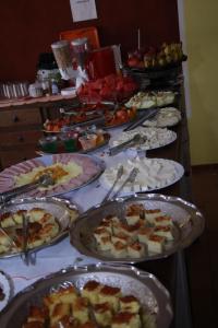 una mesa con muchos platos de comida. en Pousada al Castello di Giulietta e Romeo, en Pirenópolis