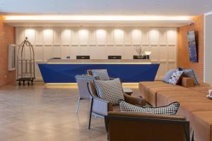 une salle d'attente avec des chaises et un comptoir bleu dans l'établissement Blue Hippo Hotel, à Ban Khlong Samrong