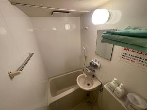 a bathroom with a sink and a toilet and a mirror at 遊悠館 in Tokyo