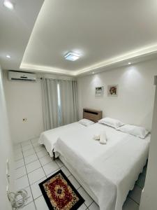 a bedroom with a white bed with two towels on it at Apto Vista Beira Mar - Praia do Futuro a 100 mt da Praia in Fortaleza