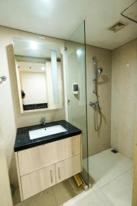 uma casa de banho com um lavatório e um chuveiro em Warhol Residence at Louise Kienne Simpang Lima Semarang em Semarang