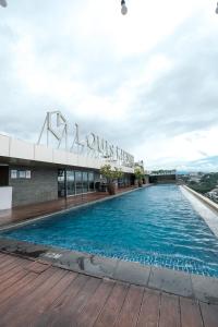 une piscine sur le toit d'un bâtiment dans l'établissement Warhol Residence at Louise Kienne Simpang Lima Semarang, à Semarang