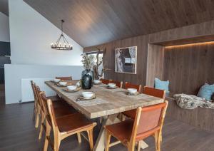 a dining room with a large wooden table and chairs at Snow Gum in Mount Hotham