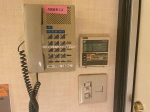 a telephone on a wall with a pay phone at 遊悠館 in Tokyo