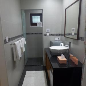 La salle de bains est pourvue d'un lavabo et d'un miroir. dans l'établissement Mi Casa Homestay, à Jiufen