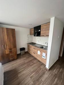 uma cozinha com armários de madeira e uma bancada em Apartaestudio en Bogota. em Bogotá