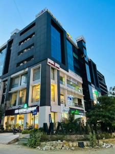 Un alto edificio nero con dei cartelli davanti. di Hotel Royal Ican Sindhu Bhavan Road a Ahmedabad