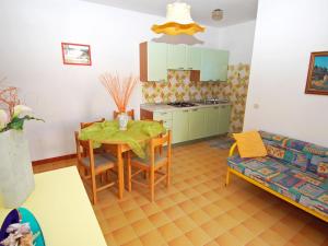 uma cozinha e sala de estar com uma mesa e um sofá em Sun drenched seaside holiday home close to Venice em Rosolina Mare