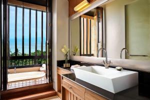 a bathroom with a large white sink and a tub at Renaissance Koh Samui Resort & Spa in Lamai