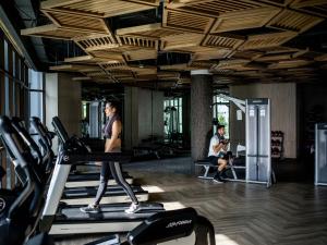 a woman walking on a treadmill in a gym at InterContinental Phuket Resort by IHG in Kamala Beach