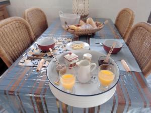 a table with a tray with glasses of orange juice at La tiote roulotte in Marquigny