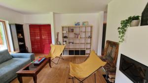 ein Wohnzimmer mit einem Sofa und zwei gelben Stühlen in der Unterkunft Kurešček in Ig