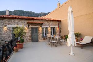 un patio con sombrilla, mesa y sillas en Guesthouse Simou with view 3 bedrooms, en Arachova