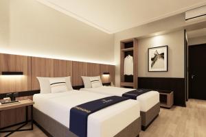a hotel room with a large bed and a desk at Fieris Hotel & Convention Kertajati in Dawuhan
