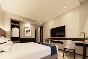a hotel room with a bed and a tv at Fieris Hotel & Convention Kertajati in Dawuhan