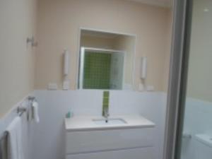 a white bathroom with a sink and a mirror at Reflections Eden - Holiday Park in Eden