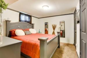 1 dormitorio con 1 cama grande con colcha de color naranja en Cozy Missouri Retreat with Deck and Grill, Near Hiking en Lees Summit