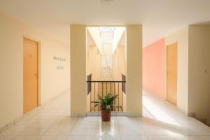 a hallway with a potted plant in a building at Sans Hotel Aurum Semarang in Semarang