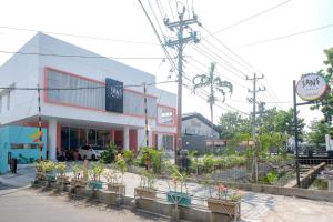 a building with potted plants in front of it at Sans Hotel Aurum Semarang in Semarang