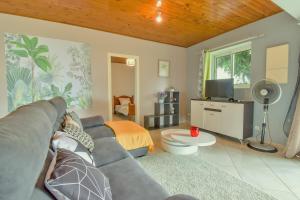 ein Wohnzimmer mit einem Sofa und einem TV in der Unterkunft AU MEUBLE DURANTAS in Petite Île