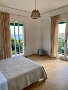 a bedroom with a large bed and large windows at Chez Lina - Appartamento Marina in Trapani