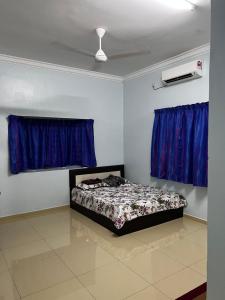 - une chambre avec un lit dans une pièce dotée de rideaux bleus dans l'établissement VINDRA HOMESTAY, à Bidur