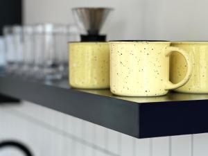 deux tasses à café jaunes posées sur une étagère dans l'établissement Roam America Horseshoe Bend, à Page