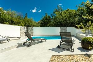 a patio with two chairs and a swimming pool at Holiday home Krk -with private pool in Soline