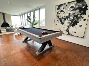 un tavolo da biliardo in un soggiorno con un dipinto di Urban Oasis: Stylish Mid-Century Home in Weho a Los Angeles